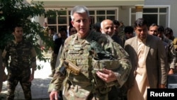 FILE - U.S. Army General John Nicholson, commander of Resolute Support forces and U.S. forces in Afghanistan, walks with Afghan officials during an official visit in Farah province, Afghanistan, May 19, 2018. 