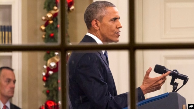 El presidente Obama visto a través de una ventana mientras se dirige a la nación de la Oficina Oval de la Casa Blanca.