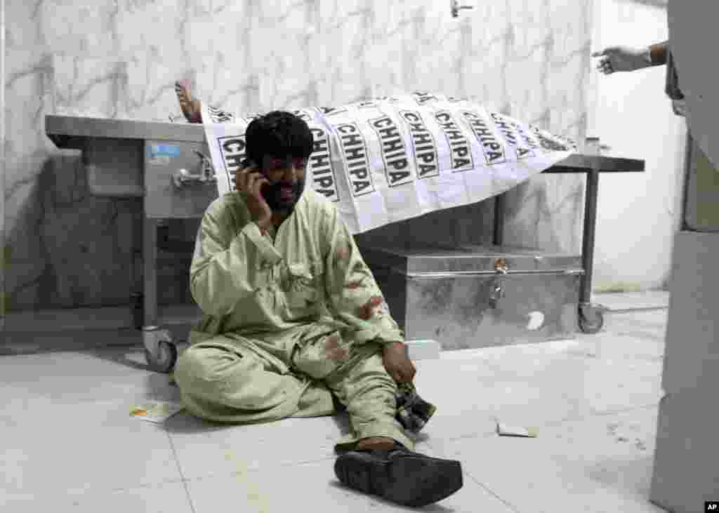 파키스탄 중서부 퀘타의 병원에서 남성이 피가 얼룩진 옷을 입고 전화 통화를 하고 있다. 이날 퀘타 근교 시장에서 폭탄테러가 발생해 31명이 죽거나 다쳤다.&nbsp;