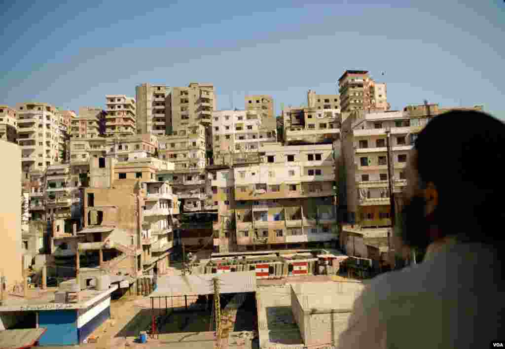 Sheikh Bilal Masri surveys the rival Jebel Mohsen neighborhood across Syria Street from his Bab Tabbaneh home during a brief ceasefire in Tripoli, Lebanon, August 25, 2012. (VOA/Jeff Neumann)