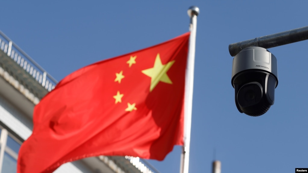 北京街头飘扬的一面中国国旗旁的一个监控摄像头。（2021年11月25日）(photo:VOA)