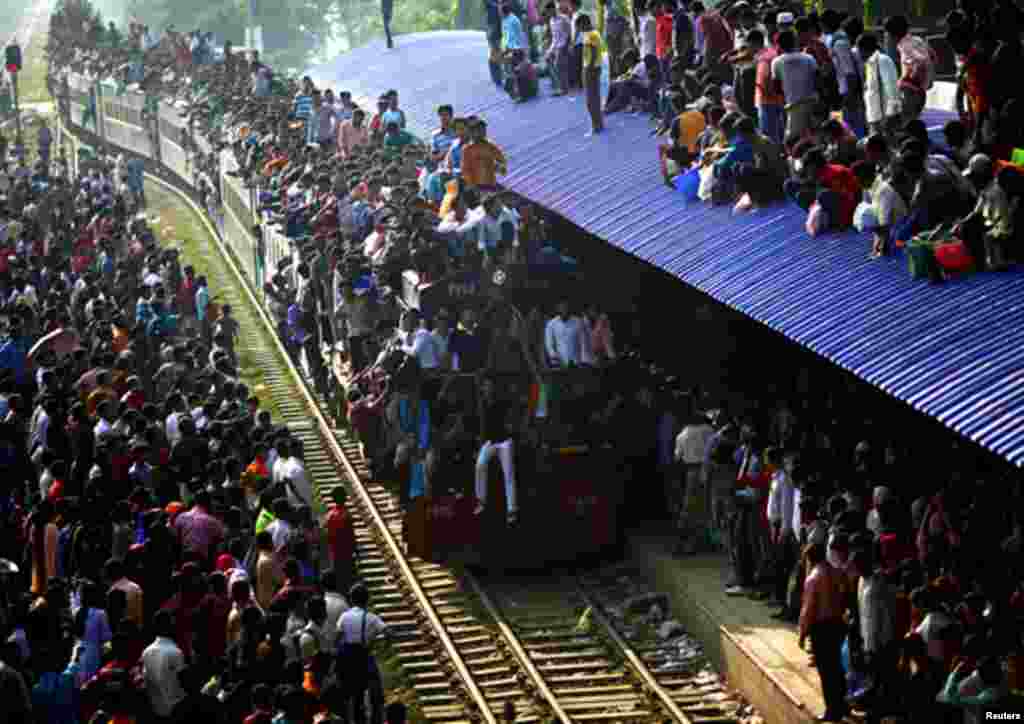 An overcrowded train approaches as other passengers wait to board at a railway station in Dhaka, November 16, 2010. Millions of residents in Dhaka are travelling home from the capital city to celebrate the Eid al-Adha holiday. (Andrew Biraj/Reuters)