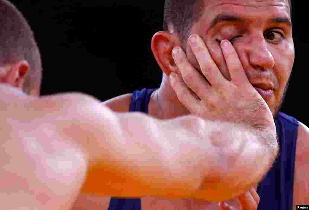 Tunisia's Hassine Ayari (L) fights with Morocco's Choukri Atafi on the Men's 96Kg Greco-Roman wrestling.