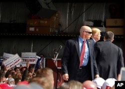 FILE - Secret Service agents guard Republican presidential candidate Donald Trump after a man rushed the stage during a campaign rally at the Wright Brothers Aero Hangar at Dayton International Airport in Vandalia, Ohio, March 12, 2016.