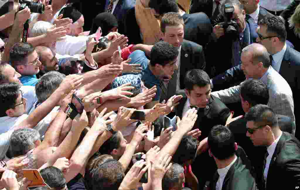 Turkish Prime Minister Recep Tayyip Erdogan, who is the front-runner in the country&#39;s presidential election, shakes hands with cheering supporters at a polling station in Istanbul.