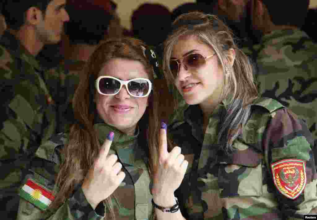 Kurdish security personnel display their ink-stained fingers after casting their votes at a polling station during early voting for the parliamentary election, Arbil, April 28, 2014.
