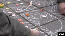 People scrawl messages on the sidewalk at the Place de la Bourse in downtown Brussels in response to the terrorist attacks that left dozens of people dead, March 23, 2016. (L. Bryant/VOA)