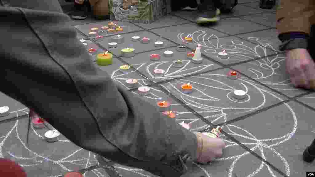 People scrawl messages on the sidewalk at the Place de la Bourse in downtown Brussels in response to the terrorist attacks that left dozens of people dead, March 23, 2016. (L. Bryant/VOA)