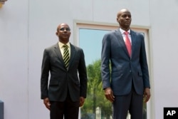 Haiti's President Jovenel Moise stands with the newly-named interim Prime Minister Jean Michel Lapin, during the national anthem at the minister's presentation ceremony in Port-au-Prince, Haiti, March 21, 2019