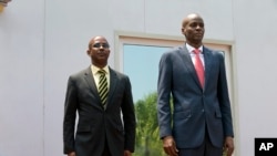 Le président haïtien Jovenel Moise aux côtés du nouveau Premier ministre par intérim, Jean Michel Lapin, lors de l'hymne national lors de la cérémonie de présentation du nouveau chef de gouvernement à Port-au-Prince, à Haïti, le 21 mars 2019.
