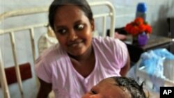 A newly born baby girl is seen as her mother looks on at Castle hospital in Colombo, Sri Lanka.