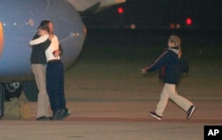 Jeffrey Fowle is greeted by his son and other family members upon his arrival, early Wednesday, Oct. 22, 2014, at Wright-Patterson Air Force Base, Ohio.