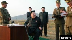 북한 김정은 국방위원회 제1위원장(가운데)이 지난달 말 공군 '검열비행훈련'을 참관하고 있다. 최룡해 당 비서(가운데 오른쪽)와 오일정 당 부장(가운데 왼쪽)이 밀착 수행하고 있다.