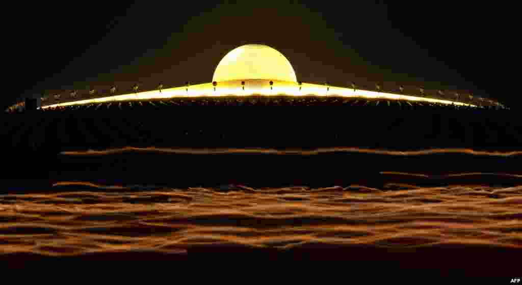 A long exposure photo shows light streaking from the candles of Buddhist monks as they walk around a Pagoda on Makha Bhucha Day at the Dhammakaya Temple in Thailand. Makha Bhucha day is observed on the full moon of the third lunar month and commemorates the day when 1,250 monks gathered to be ordained by the Buddha. (AFP)