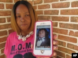 Barbara O'Neal holds her smartphone, which displays a photograph of her slain son, Alan O'Neal Jr., in Savannah, Ga., July 31, 2017. O'Neal started the group Mothers of Murdered Sons in Savannah after her 20-year-old son was fatally shot during an attempted robbery in 2011.