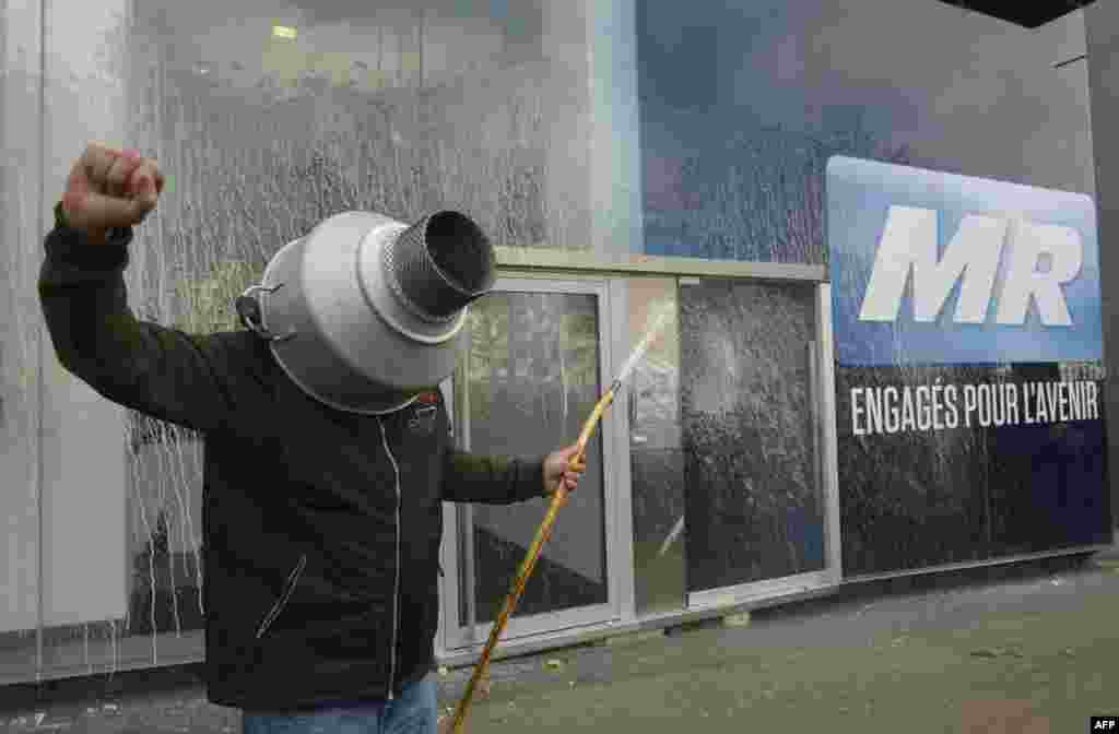 A farmer sprays milk on the frontage of the headquarters of the Belgian right wing liberal party Mouvement Reformateur (MR) during a demonstration in Brussels.