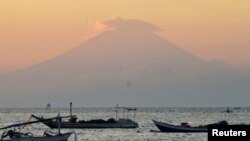 Mount Agung, an active volcano located on the resort island of Bali that has been placed on alert level 3 following recent seismic activity, is seen from Mataram on nearby Lombok island, Indonesia, Sept. 21, 2017, in this photo taken by Antara Foto. 