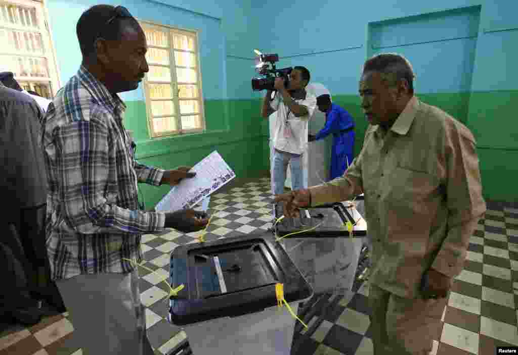 A voter prepares to cast his ballot during electons in Khartoum, April 13, 2015.