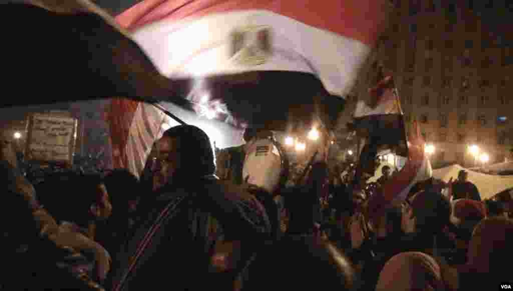 Penabuh drum dikelilingi bendera-bendera dalam jam-jam menegangkan sebelum pidato Presiden Mubarak di Kairo, 10 Februari 2011.