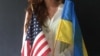 Xenia Vitovych, who was born in Ukraine, holds U.S. and Ukrainian flags at Saint George Academy, New York, Sept. 10, 2014 (Adam Phillips/VOA).