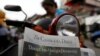 FILE - A woman buys the final issue of The Cambodia Daily newspaper at a store along a street in Phnom Penh, Cambodia, Sept. 4, 2017. 