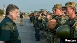 Presiden Petro Poroshenko (kiri) berbicara dengan anggota pasukan Ukraina di kota Mariupol, Senin (8/9).