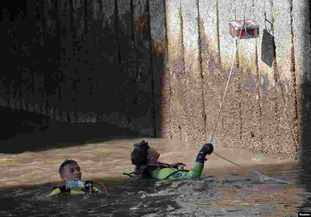 Divers recover pieces of evidence after a man threw an explosive from a bridge at Sathorn pier in central Bangkok, Thailand, a day after a bomb at a city shrine killed 22 people, including nine foreigners.