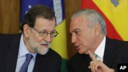 Spanish Prime Minister Mariano Rajoy, left, leans in to hear Brazil's President Michel Temer, during a meeting at the Planalto presidential palace, in Brasilia, Brazil, April 24, 2017. 