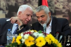 Senior Fatah official Azzam al-Ahmad, left, talks to Gaza's Hamas Prime Minister Ismail Haniyeh, during a press conference at Haniyeh's residence in Gaza Strip, Apr. 23, 2014.