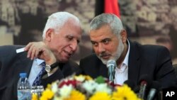 Giới chức cao cấp của Fatah, Azzam al-Ahmad, trái, nói chuyện với Thủ tướng Gaza của phe Hamas,Ismail Haniyeh, trong một cuộc họp báo ở Dải Gaza Strip, 23/4/2014,