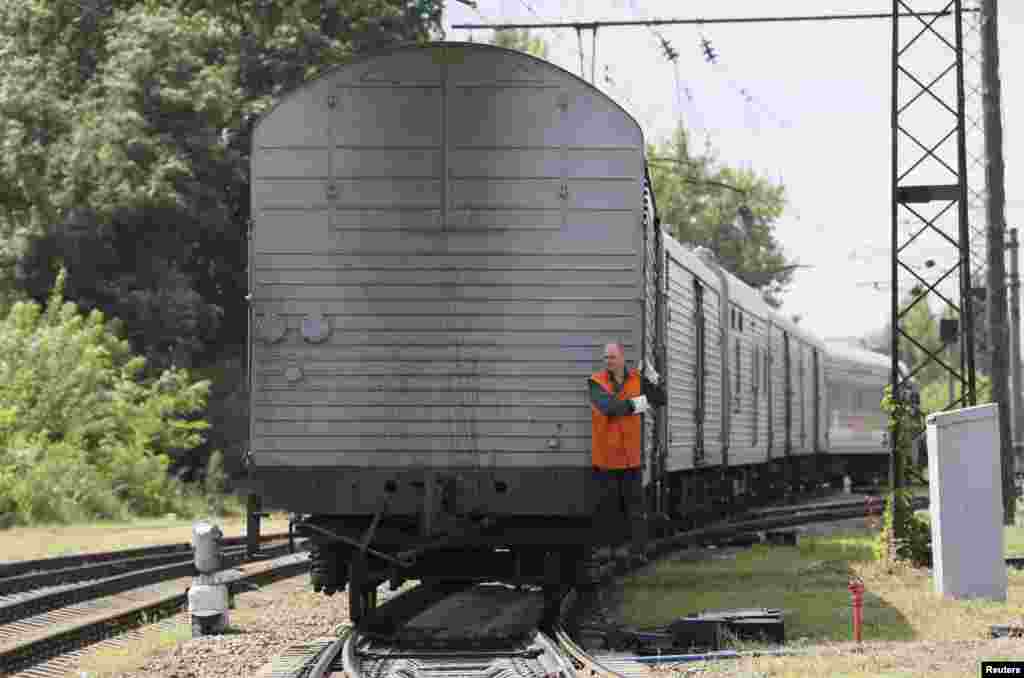 A guard rides on a train carrying the remains of victims of Malaysia Airlines MH17 downed over rebel-held territory in eastern Ukraine as it arrives in the city of Kharkiv, under Kyiv&#39;s control, July 22, 2014.
