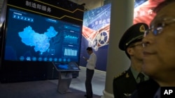 FILE - Visitors look at a display of information technologies at an exhibit highlighting China's achievements under five years of Xi Jinping's leadership at the Beijing Exhibition Hall in Beijing, China, Oct. 17, 2017.