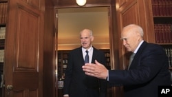 Greece's President Karolos Papoulias (R) welcomes Prime Minister George Papandreou at his office inside the Presidential Palace in Athens, November 5, 2011.