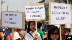 FILE - Indonesian gay activists hold posters during a protest demanding equality for LGBT (Lesbian, gay, bisexual and transgender) people in Jakarta, Indonesia, May 21, 2011.