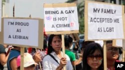 FILE - Indonesian gay activists hold posters during a protest demanding equality for LGBT (Lesbian, gay, bisexual and transgender) people in Jakarta, Indonesia, May 21, 2011.
