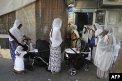 FILE - Christian African Eritrean migrants gather ahead of praying at a makeshift church in southern Tel Aviv on Sept. 2, 2017.