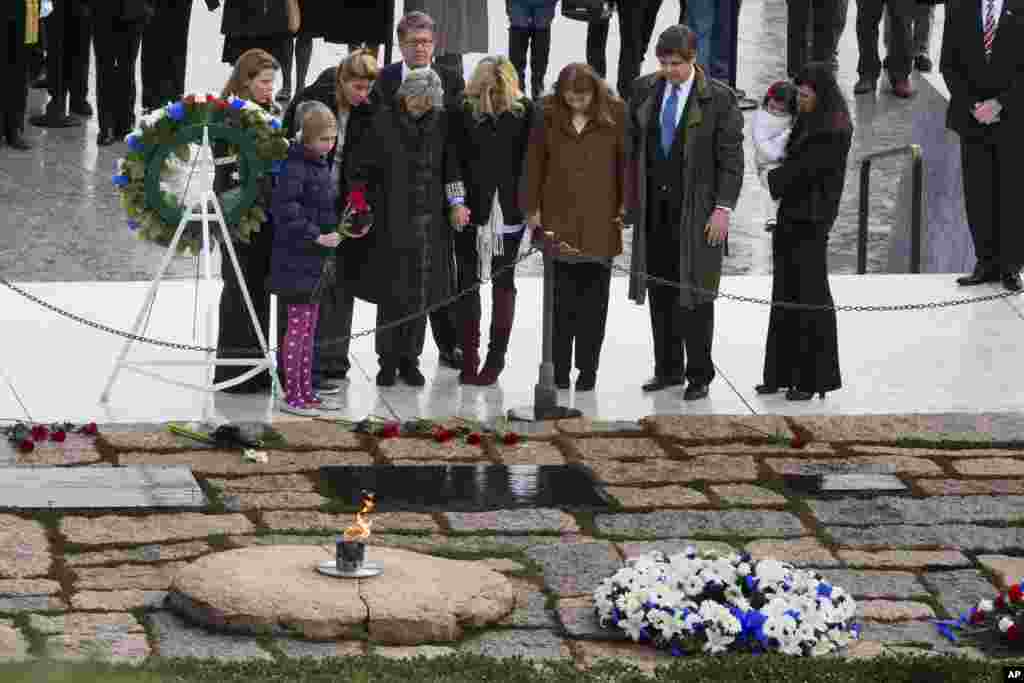 Members of the Kennedy family, including former U.S. Ambassador to Ireland, Jean Kennedy Smith, fourth from left, hold hands as they pay their respects at the gravesite of President John F. Kennedy, Nov. 22, 2013, at Arlington National Cemetery, Washington.