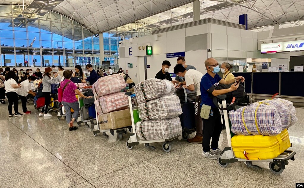 英国LOTR安排届满前夕，7月18日晚香港国际机场出现移居英国的人潮，他们推着堆积如山的行李，港人惯用的大型”红白蓝袋”成为机场特别的风景。 （美国之音/汤惠芸）(photo:VOA)