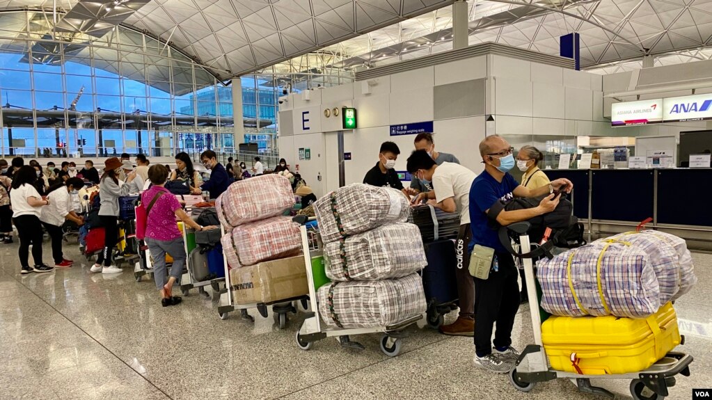 英国LOTR安排届满前夕，7月18日晚香港国际机场出现移居英国的人潮，他们推着堆积如山的行李，港人惯用的大型”红白蓝袋”成为机场特别的风景。（美国之音汤惠芸）(photo:VOA)