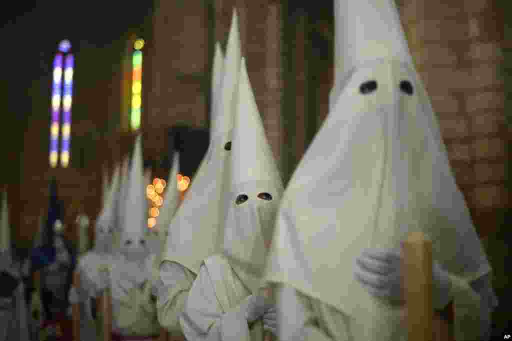 Hooded penitents from &quot;La Borriquita&quot; brotherhood take part during a Holy Week procession in Cordoba, Spain.