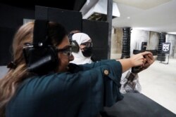 Perempuan pelatih menembak, Mona Al Khurais mengajar menembak seorang perempuan Saudi di lapangan tembak Top-Gun di Riyadh, Arab Saudi, 28 Oktober 2021. (REUTERS/Ahmed Yosri)