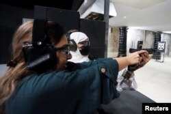 Female shooting coach Mona Al Khurais teaches shooting a Saudi woman at the Top-Gun shooting range in Riyadh, Saudi Arabia, October 28, 2021. (REUTERS/Ahmed Yosri)