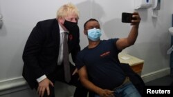Britain's Prime Minister Boris Johnson visits Woodgrange GP Surgery vaccination centre as people receive coronavirus disease (COVID-19) booster vaccine, in London, Nov. 15, 2021. (Jeremy Selwyn/Pool via Reuters)