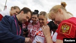 Russia's Prime Minister Dmitry Medvedev (L) meets with members of the Russian Olympic team as he visits the Olympic Village at the London 2012 Olympic Games in London July 28, 2012.