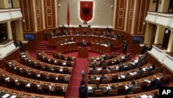 FILE - Albania's Prime Minister Edi Rama delivers a speech to the parliament with the seats of the main opposition Democratic party, left, empty, during an assembly session in Tirana, Feb. 23, 2017.