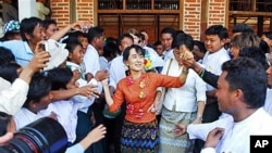 Burma pro-democracy leader Aung San Suu Kyi greets supporters at Kyit Tee village, in Myaing township, central Burma, January 31, 2012.