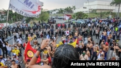 Para anggota serikat buruh memprotes pengesahan Undang-Undang Cipta Kerja, di Kawasan Industri Jakarta Timur, di Bekasi, Senin, 5 Oktober 2020. (Foto: Antara via Reuters)