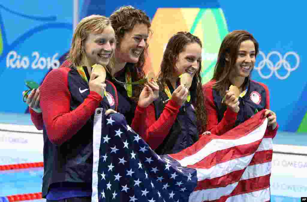The United States team, Katie Ledecky, Allison Schmitt, Leah Smith and Maya DiRado, from left, hold up their gold medals after winning the women's 4x200-meter freestyle relay during the swimming competitions at the 2016 Summer Olympics, Thursday, Aug. 11,