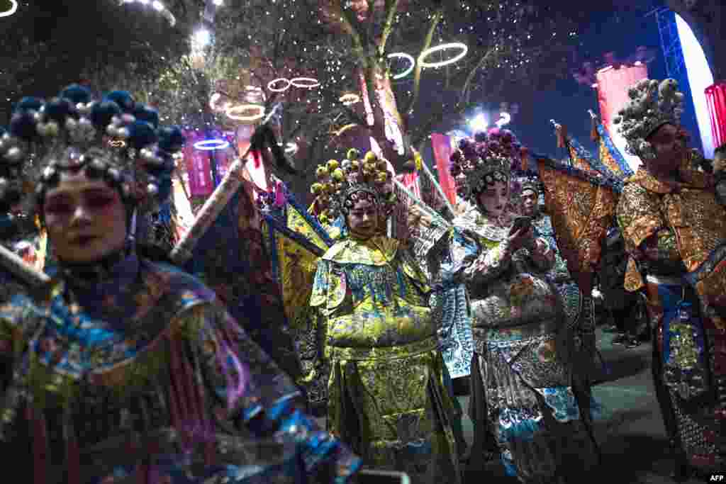 رقصنده ها با لباس های سنتی و مخصوص آماده برای شرکت در رژه ای که به مناسبت فرا رسیدن سال نو چینی تدارک دیده شده است. &nbsp;