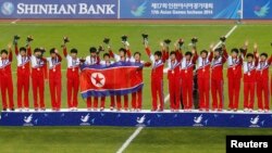 1일 인천 아시안게임 여자 축구 결승전에서 일본을 꺽고 금메달을 차지한 북한 선수팀이 시상식에서 손을 흔들고 있다.